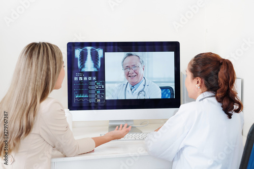 Doctor and female patient getting consultation of experienced senior Asian orthopedic surgeon online