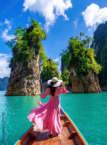 Canvas Print Beautiful girl standing on the boat and looking to mountains in Ratchaprapha Dam at Khao Sok National Park, Surat Thani Province, Thailand