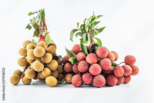 A handful of fresh longan and a red lychee on a white background