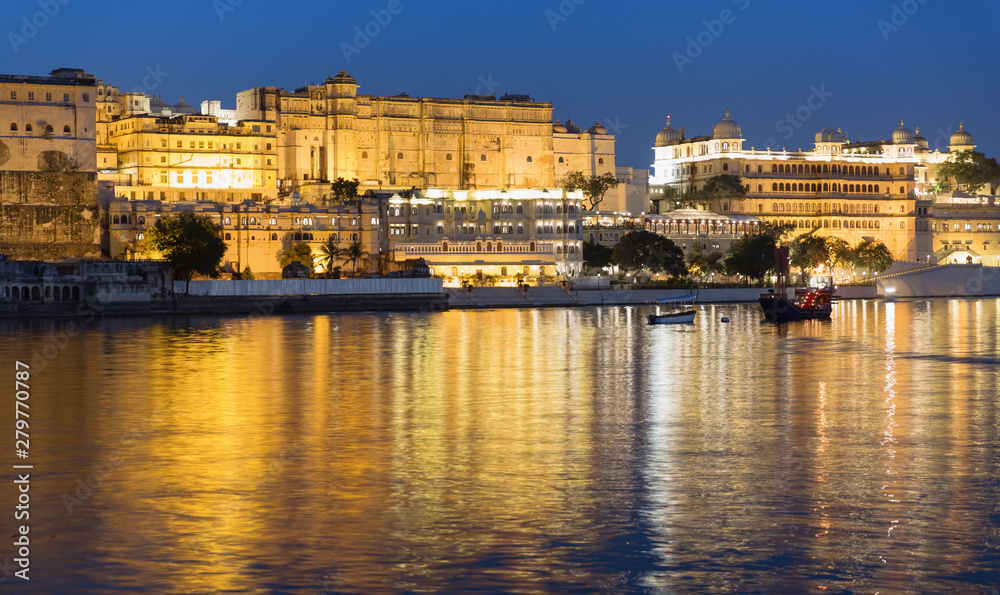 Historic Udaipur City palace illuminated at Blue hour. Beautiful reflections on Lake Pichola. Long exposure Shot from Ambrai Ghat. Post sunset view with Boat rides 