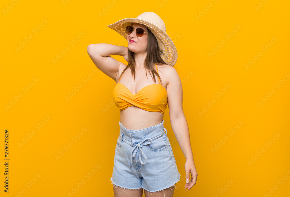 Young caucasian woman wearing a straw hat, summer look suffering neck pain due to sedentary lifestyle. Young caucasian woman wearing a straw hat, summer look suffering neck pain due to sedentary lifestyle.