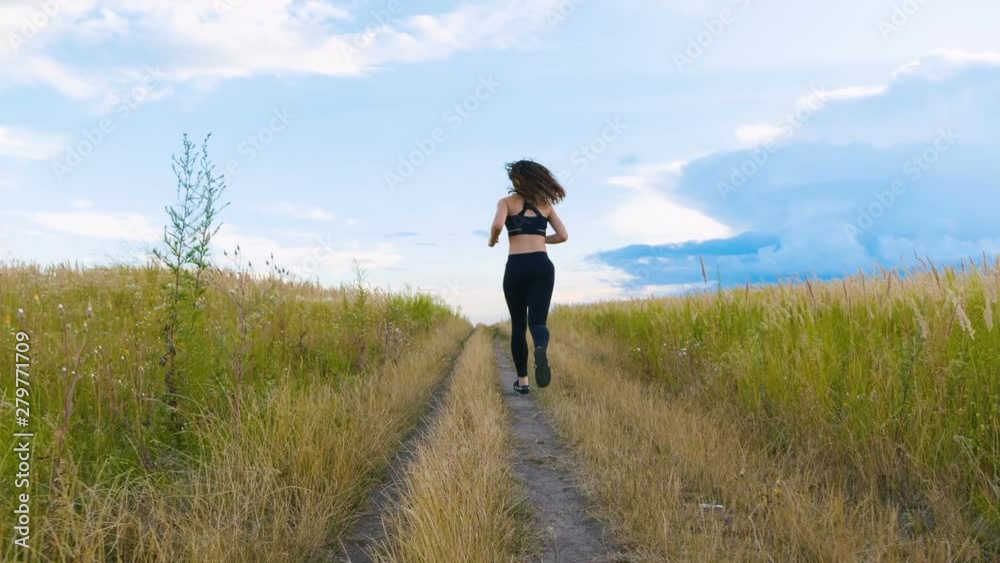 Fit Woman Jogging Exercising Running Cardio outdoor at summer field. Workout Female Runner. Fit Woman Jogging Exercising Running Cardio outdoor at summer field. Workout Female Runner.