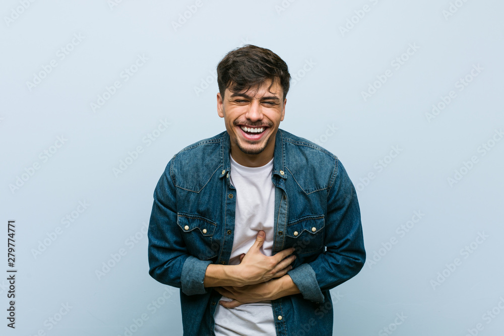 Young hispanic cool man laughs happily and has fun keeping hands on stomach. Young hispanic cool man laughs happily and has fun keeping hands on stomach.
