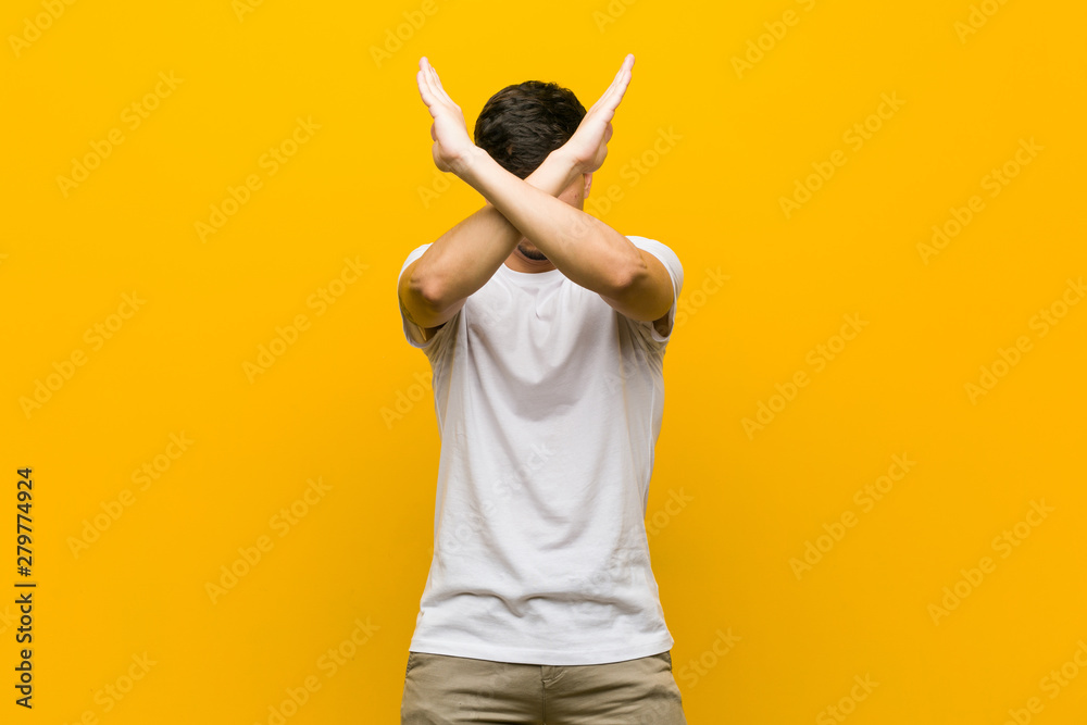 Young hispanic casual man keeping two arms crossed, denial concept. Young hispanic casual man keeping two arms crossed, denial concept.