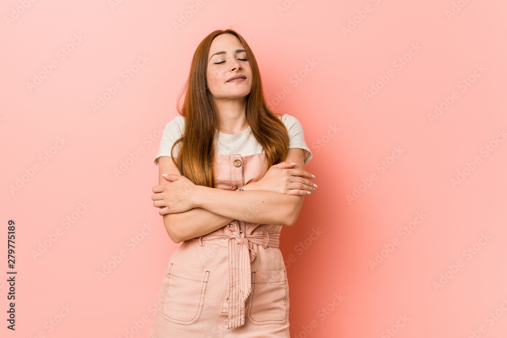 Obraz premium Young ginger woman with freckles hugs, smiling carefree and happy.