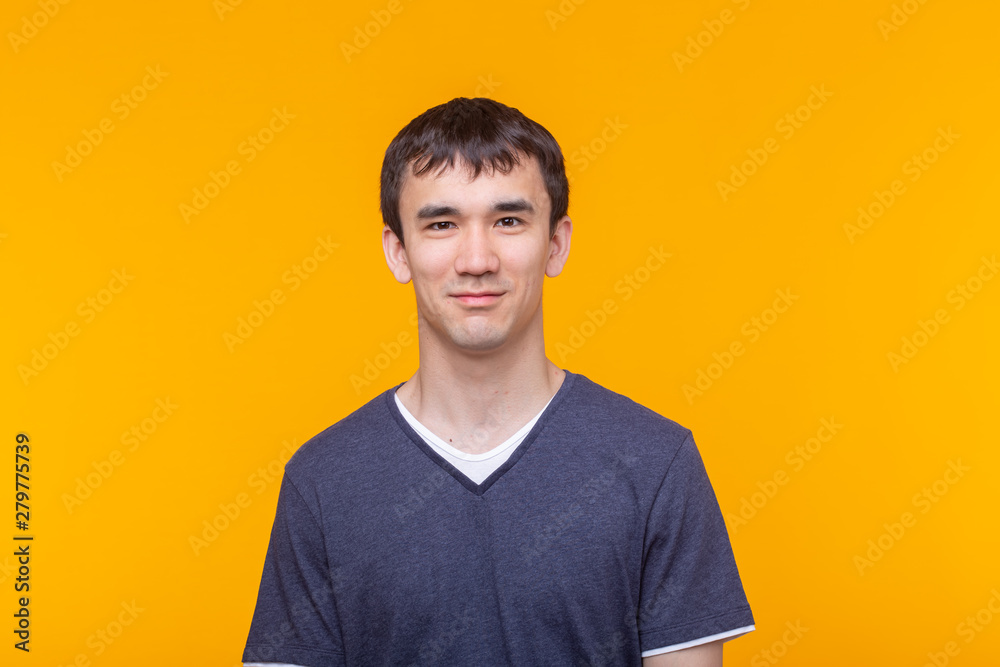 Asian handsome man wearing blue t-shirt on yellow background Asian handsome man wearing blue t-shirt on yellow background