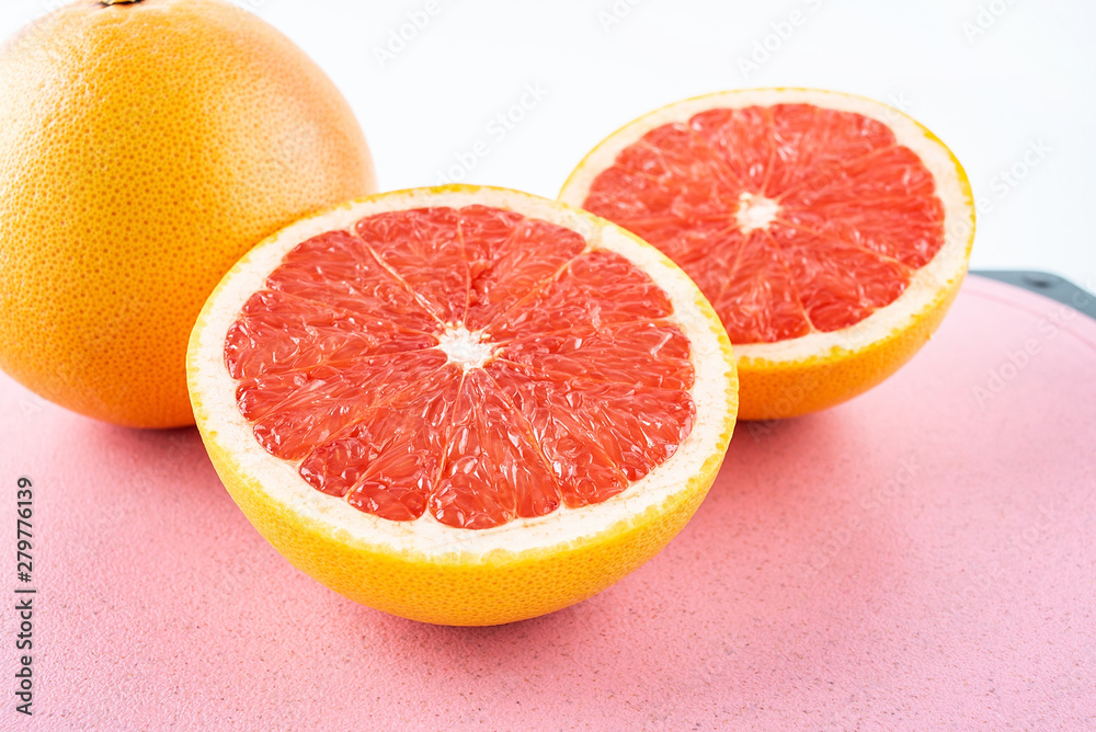 Fresh grapefruit and cut red flesh on cutting board Fresh grapefruit and cut red flesh on cutting board