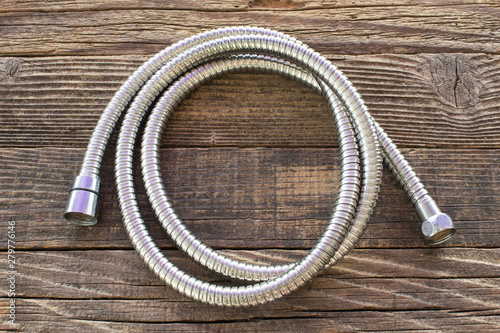 Water hose for shower on wooden background
