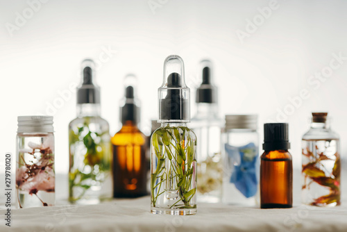 Transparent Bottles of essential oil with fresh herbs. photo