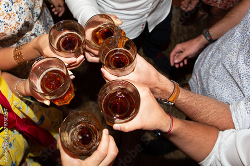 Top view clinking glasses with drink in hands holiday party cheers of friends in pub bar