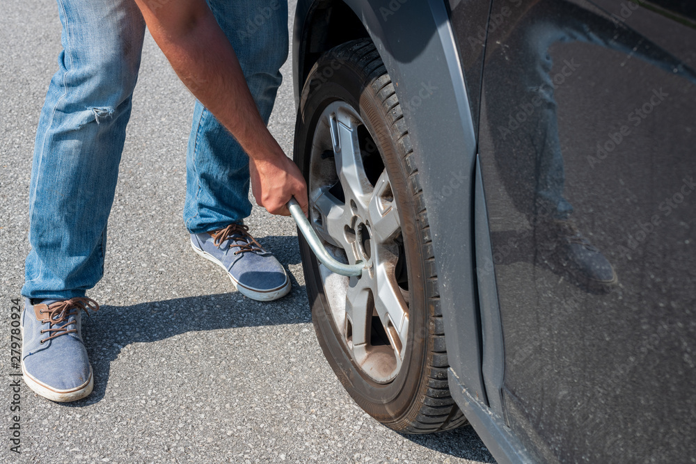Mann wechselt platten reifen am Auto aus Mann wechselt platten reifen am Auto aus
