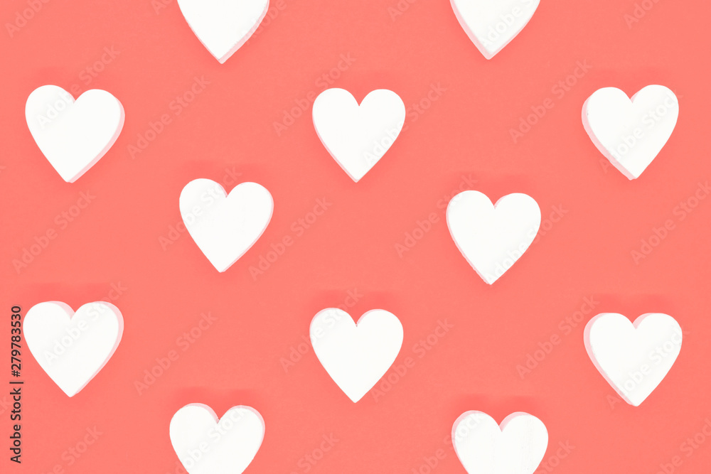 White wooden hearts on pink background
