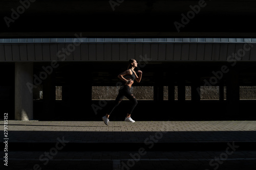 Sporty girl runs in urban street
