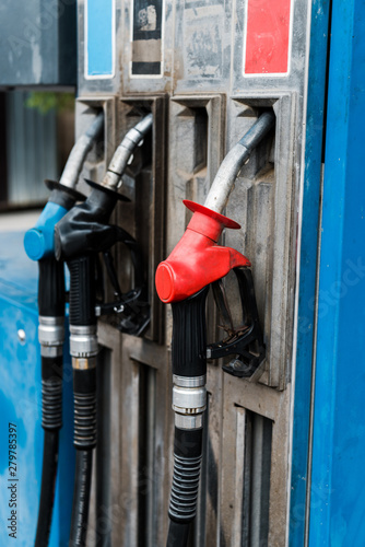 Selective focus of red and blue gas pumps with fuel on gas station