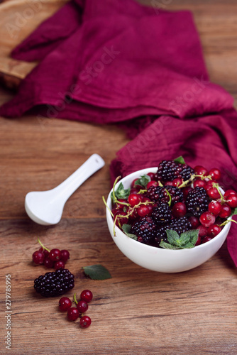 Ripe and tasty berries in white bowl on the table