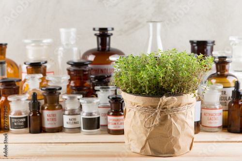 Alternative medicine concept - medicine in bottles and medicinal herbs on a wooden table