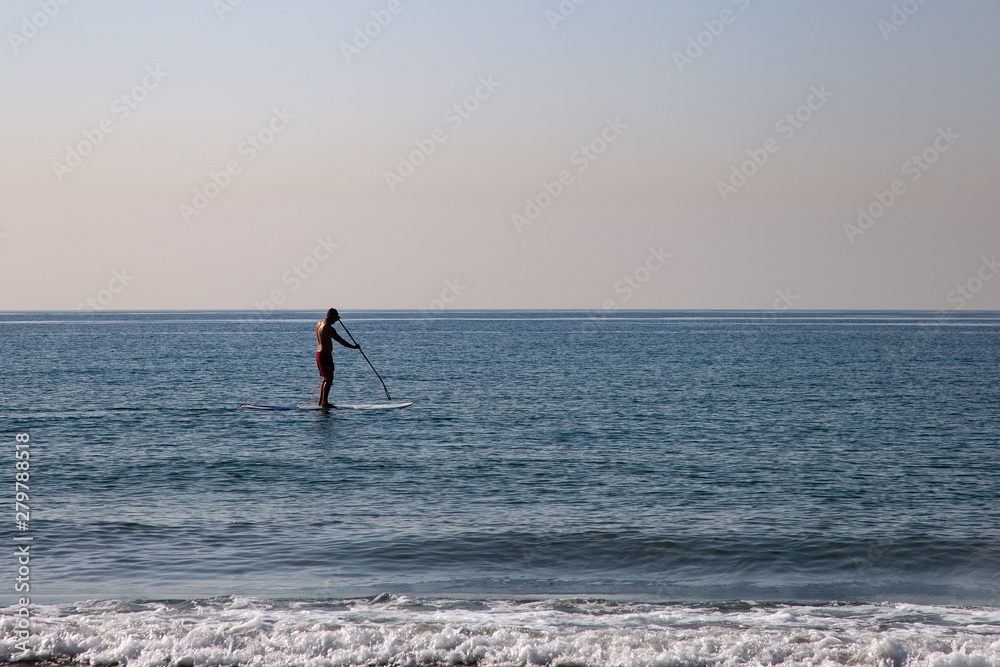Naklejka premium Silhouette of a man doing paddle surf