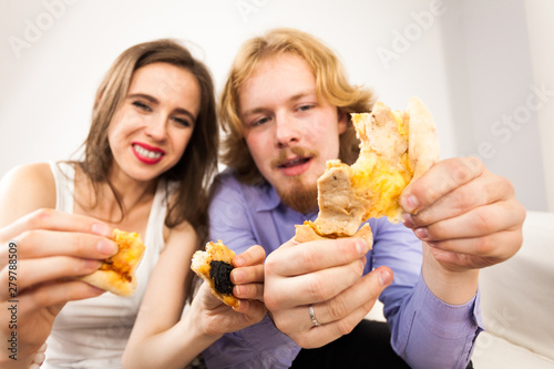 Couple eating pizza, having fun together.