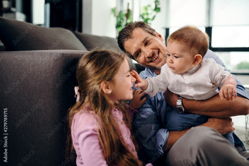 Happy father spending time with his children at home. Happy father spending time with his children at home.