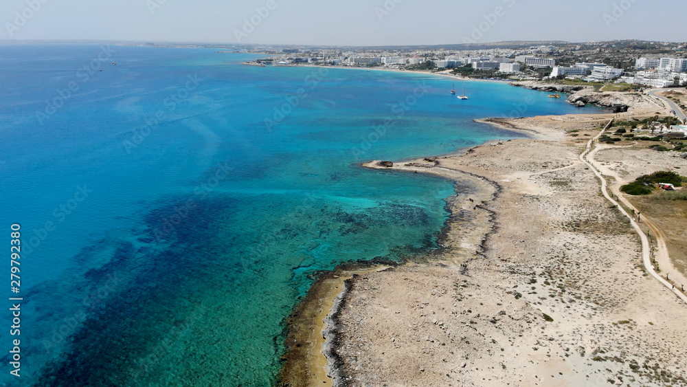 The rocky coast of Cyprus with azure water near Ayia Napa. Flying drone over the sea