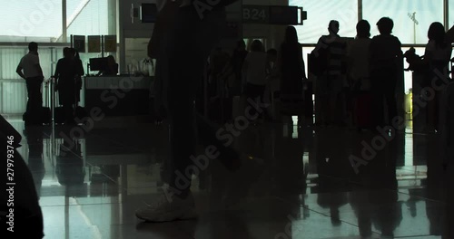 Passenger Queue at Gate before the Flight. People Silhouettes. Reflections on the Floor. Airport Boarding Hall. Time lapse. Zoom In photo