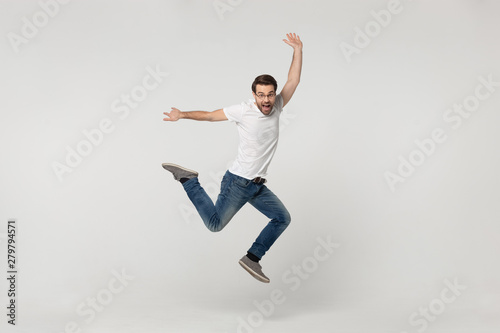 Vivacious fellow look at camera jumping isolated on grey background