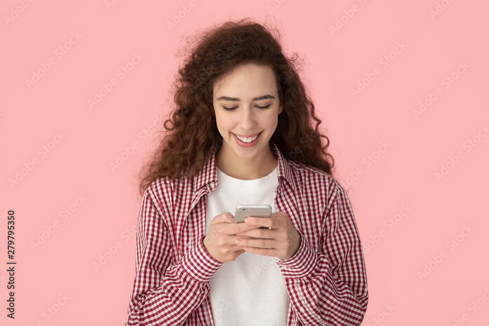 Young woman chatting using smartphone posing isolated on pink background Young woman chatting using smartphone posing isolated on pink background