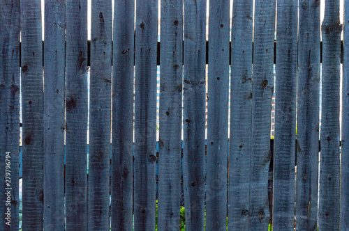 Gray old vertical planks of a wooden fence. Front view.