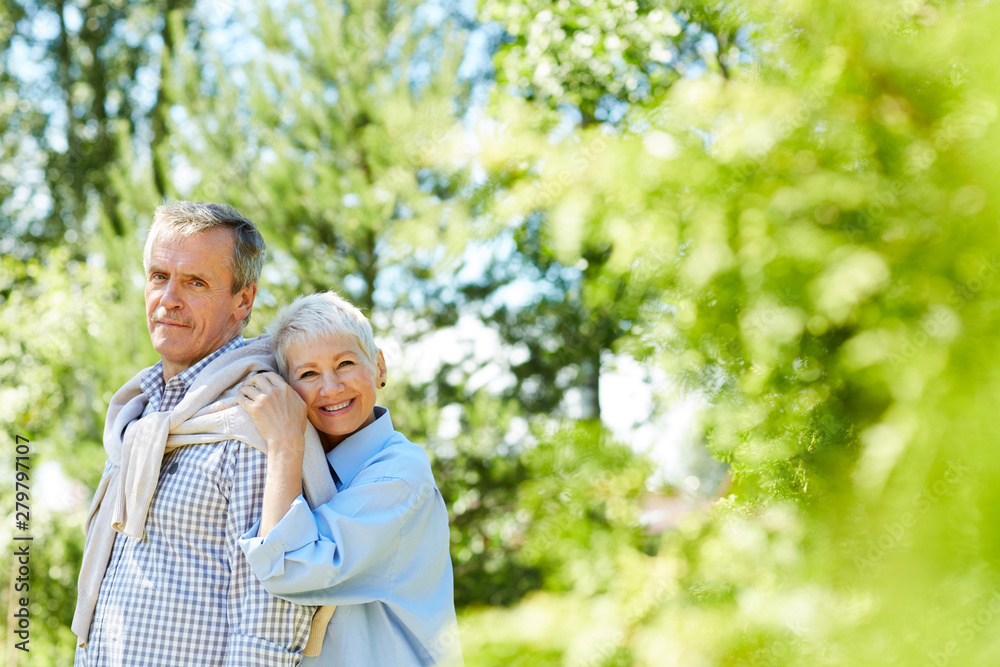 Portrait of happy senior woman leaning on her husband while taking family portrait outdoors, copy space Portrait of happy senior woman leaning on her husband while taking family portrait outdoors, copy space