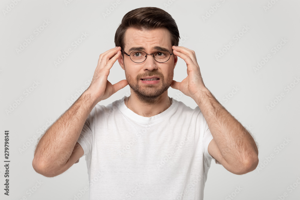 Naklejka premium Guy touching head temples experiencing stress studio shot