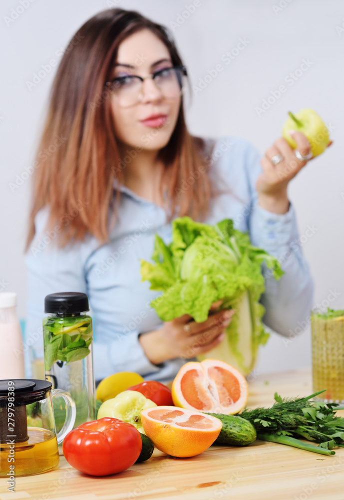 beautiful young girl holding bell peppers and cabbage in the background of a table with vegetables. Healthy food beautiful young girl holding bell peppers and cabbage in the background of a table with vegetables. Healthy food