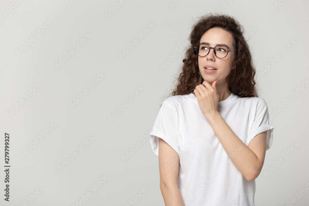 Attractive woman in glasses thinking posing isolated on grey background Attractive woman in glasses thinking posing isolated on grey background