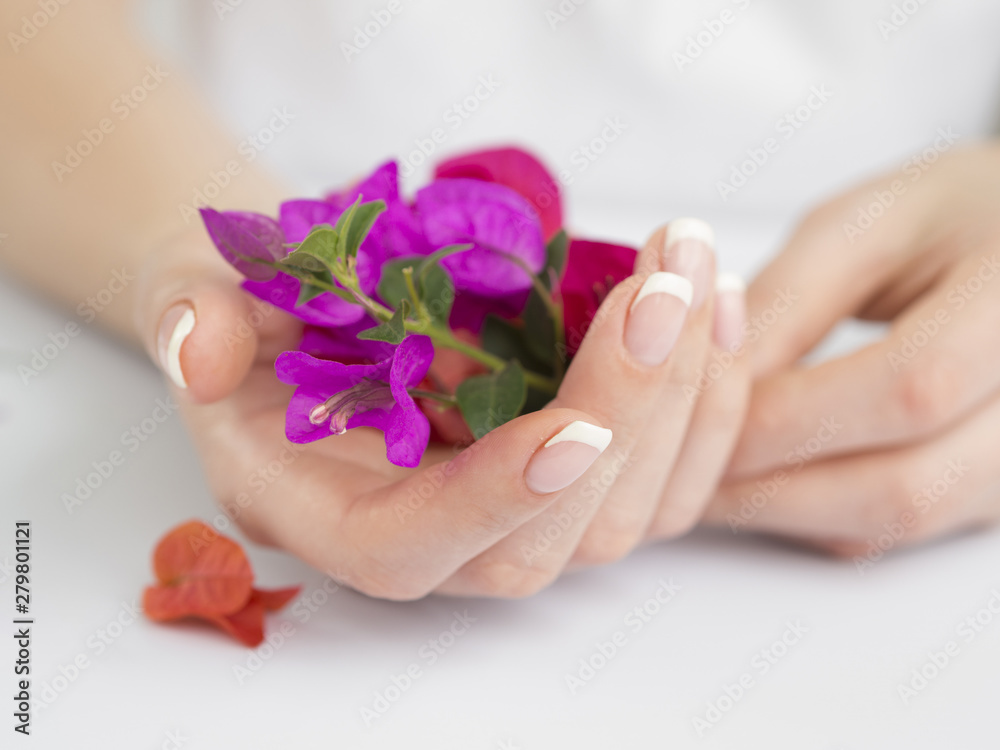 Fototapeta premium Delicate manicured hands holding flowers