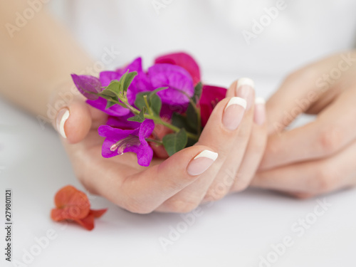 Delicate manicured hands holding flowers