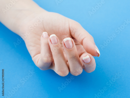 Manicured hand on blue background