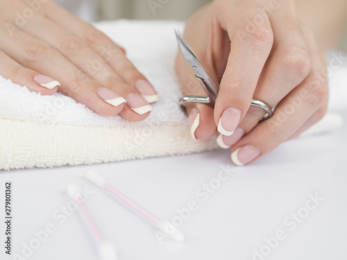 Manicured hands holding nail scissors