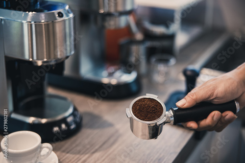 man grinding fresh coffee with coffee machine.