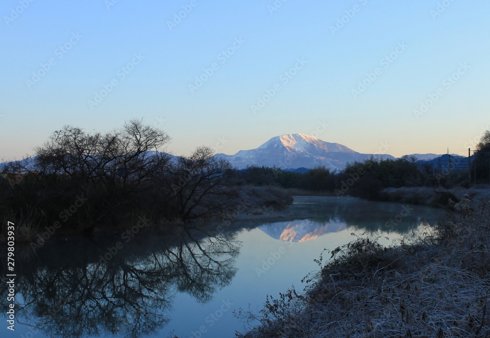 雪化粧した滋賀県の伊吹山と冬の川の景色です