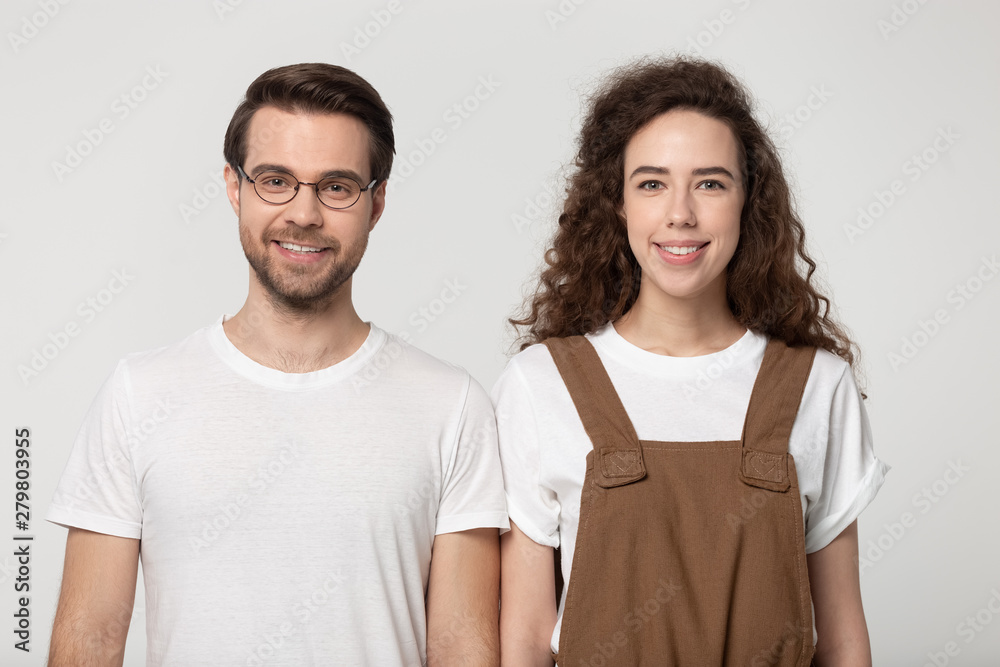 Fototapeta premium Attractive millennial girl and guy isolated on grey background