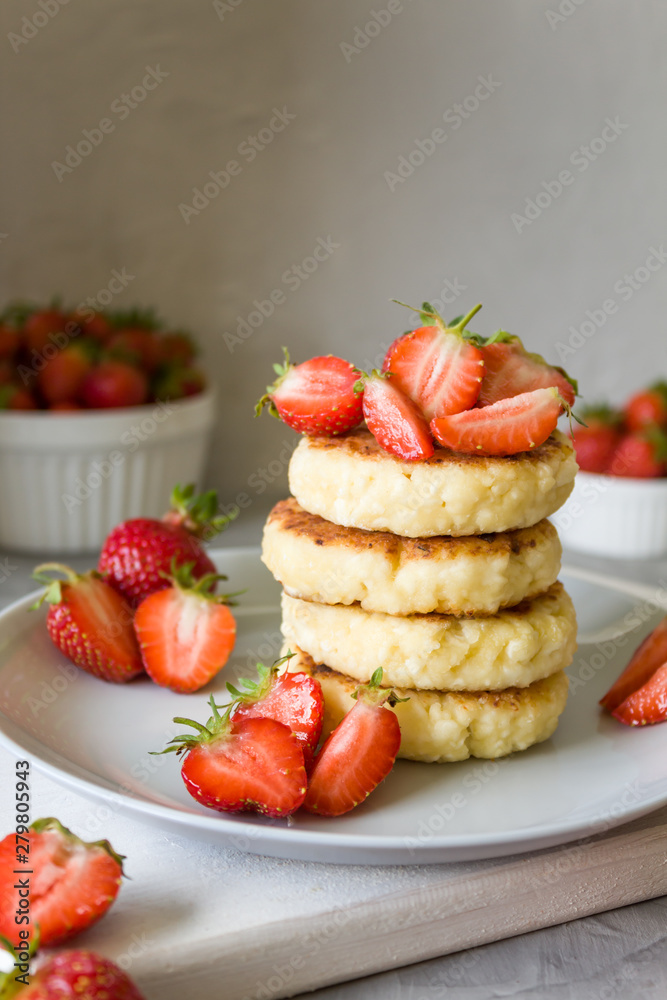 Cottage cheese pancakes syrniki with strawberrys. Delicious healthy summer Breakfast. Copy space, side view.