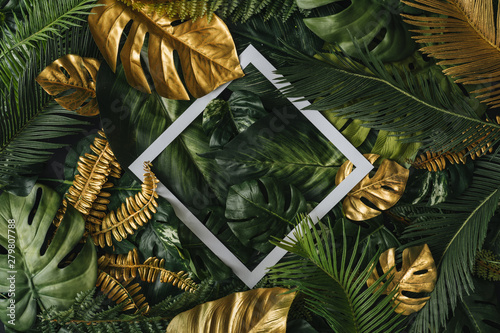 Fototapeta Naklejka Na Ścianę i Meble -  Creative nature background. Gold and green tropical palm leaves. Minimal summer abstract jungle or forest pattern. White paper frame copy space.