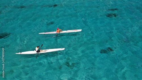 Aerial photo of fit athletes competing on sport canoe in tropical exotic bay with crystal clear turquoise sea