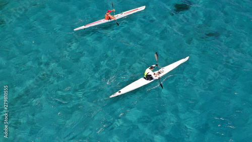 Aerial photo of fit athletes competing on sport canoe in tropical exotic bay with crystal clear turquoise sea