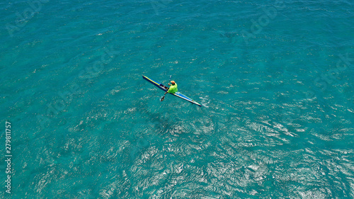 Aerial drone photo of fit men practising sport canoe in tropical open ocean bay with turquoise clear sea