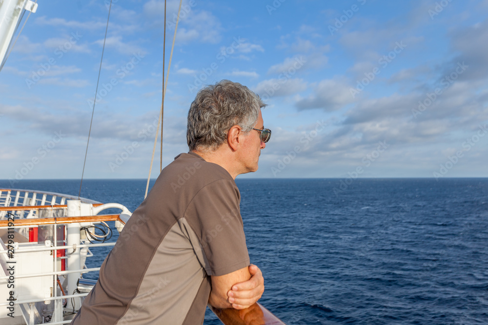 Fototapeta premium Man looking at the horizon of the sea from the deck of a cruise ship