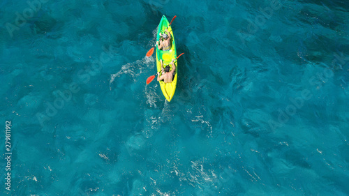 Aerial drone photo of fit couple practising on a colourful canoe in turquoise open ocean bay with crystal clear sea