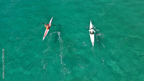 Aerial photo of fit athletes competing on sport canoe in tropical exotic bay with crystal clear turquoise sea