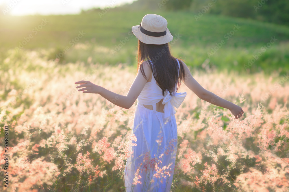 young woman walks feel freedom in the light of warm sun, bloom of wild flowers in meadow, enjoyment and peaceful in the field of meadow