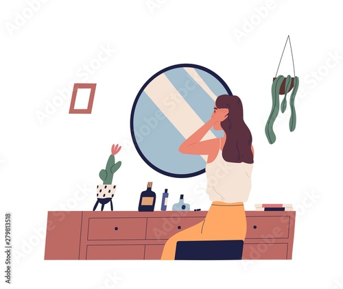 Young woman sitting at dressing table and primping her hair. Cute girl making hairstyle in front of mirror. morning routine, start of working day, everyday life. Flat cartoon vector illustration.