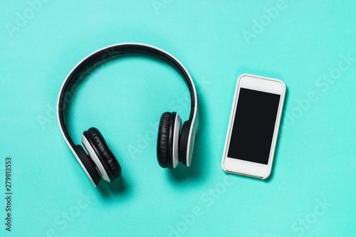 Headphones and smartphone on blue.